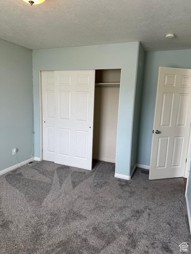 706 S 1690 W, Logan, UT 84321 - unfurnished bedroom with a closet, baseboards, dark colored carpet, and a textured ceiling