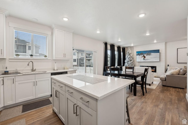 795 N Brook Ave, Tooele, UT 84074 - kitchen with a large fireplace, light wood finished floors, recessed lighting, a sink, and a center island