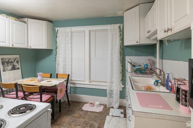 263 W Center St, Logan, UT 84321 - kitchen featuring white cabinets, a sink, white electric stove, and baseboards