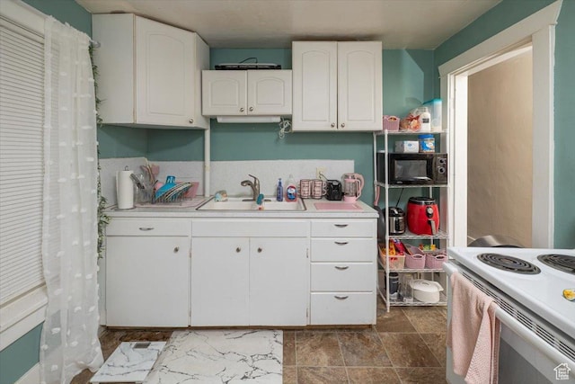 263 W Center St, Logan, UT 84321 - kitchen featuring white electric stove, light countertops, a sink, and white cabinets