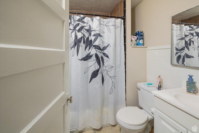 263 W Center St, Logan, UT 84321 - full bath with toilet, curtained shower, vanity, a textured ceiling, and tile walls