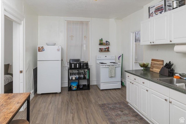 263 W Center St, Logan, UT 84321 - kitchen with white appliances, dark wood-style flooring, backsplash, a sink, and white cabinets