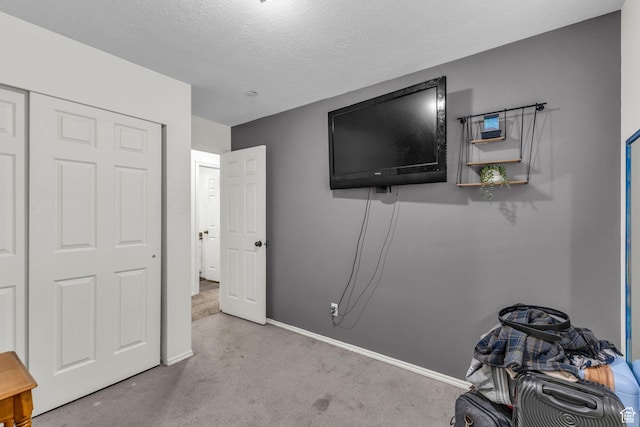 unfurnished bedroom featuring baseboards, a textured ceiling, and carpet floors