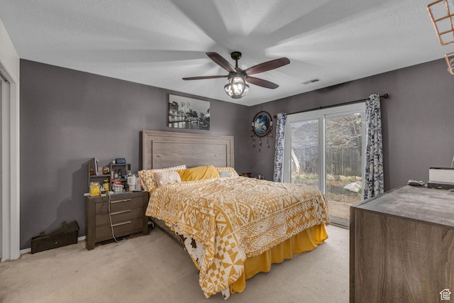 bedroom with ceiling fan, light carpet, visible vents, and access to exterior