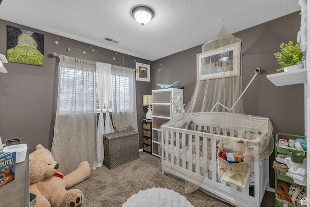 bedroom featuring carpet, a textured ceiling, and visible vents