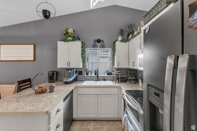 kitchen featuring a peninsula, a sink, stainless steel appliances, white cabinets, and vaulted ceiling