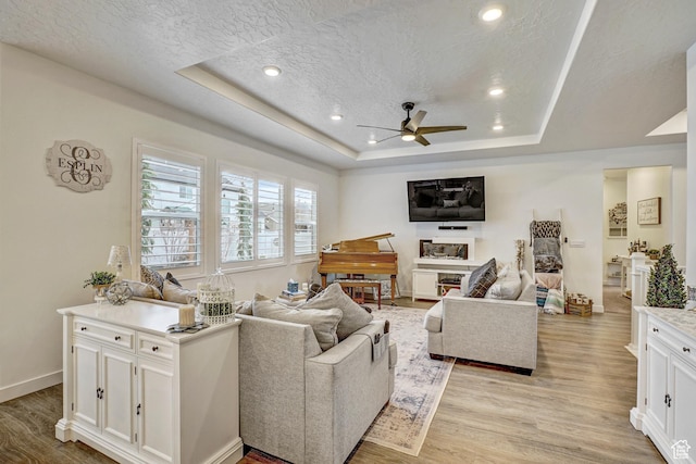 1002 E 2680 S, Heber City, UT 84032 - living room with a tray ceiling, baseboards, a textured ceiling, light wood finished floors, and a ceiling fan
