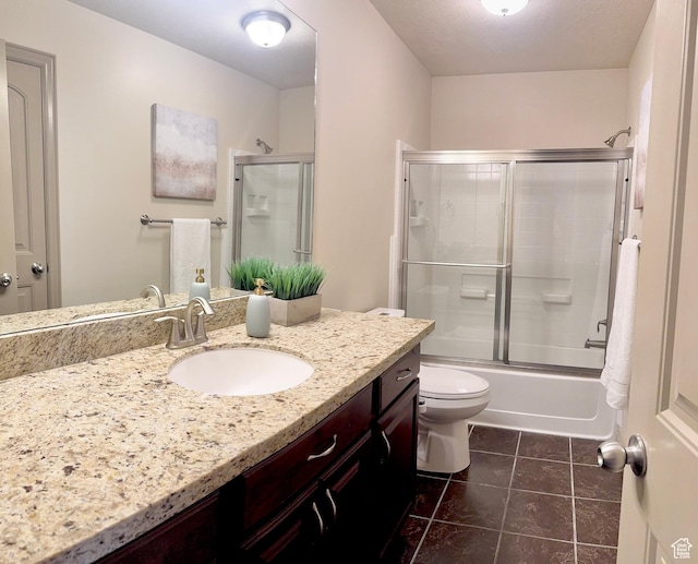 full bathroom featuring toilet, tile patterned floors, vanity, and combined bath / shower with glass door