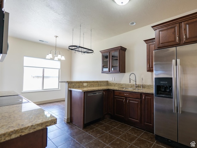 kitchen with visible vents, a sink, appliances with stainless steel finishes, a peninsula, and dark brown cabinets