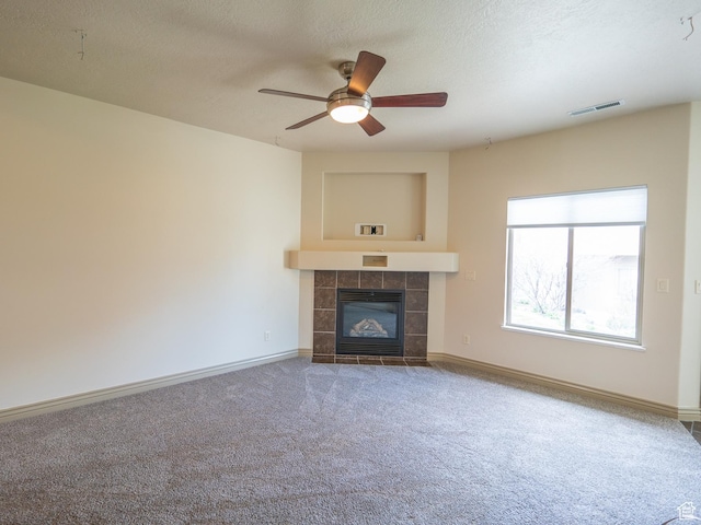 unfurnished living room featuring baseboards, a textured ceiling, a ceiling fan, carpet floors, and visible vents