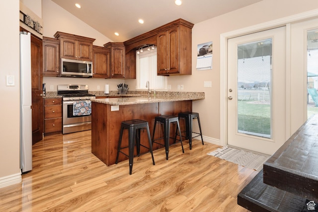 787 S 2nd W, Preston, ID 83263 - kitchen with a breakfast bar, light wood-style floors, a peninsula, and appliances with stainless steel finishes