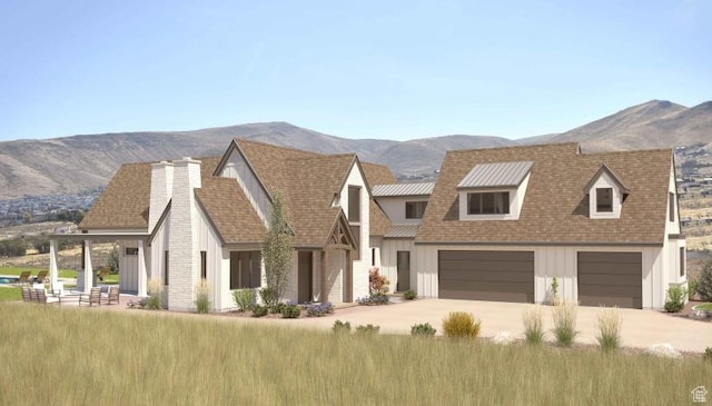 view of front of property with a chimney, an attached garage, board and batten siding, driveway, and a mountain view