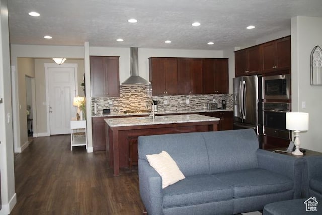 987 W 880 N, American Fork, UT 84003 - kitchen featuring backsplash, appliances with stainless steel finishes, dark wood-type flooring, wall chimney range hood, and a kitchen island with sink
