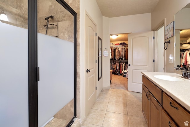 931 E Bramble Way, Washington, UT 84780 - bathroom with a stall shower, vanity, a spacious closet, a textured ceiling, and tile patterned flooring