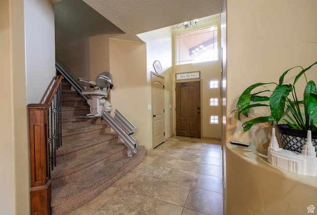931 E Bramble Way, Washington, UT 84780 - tiled foyer featuring plenty of natural light, stairs, a towering ceiling, and a textured ceiling