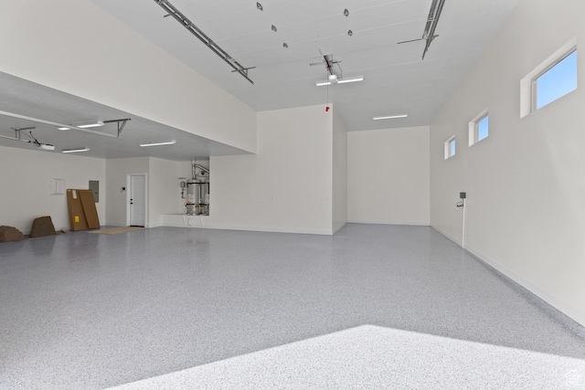 garage with baseboards and electric panel