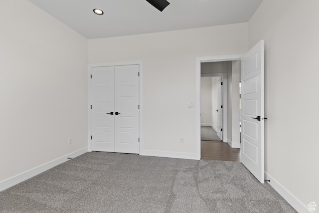 unfurnished bedroom featuring baseboards, carpet floors, a closet, and recessed lighting