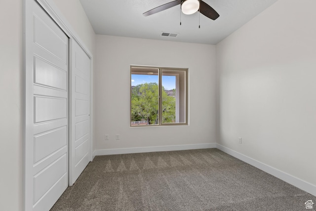 unfurnished bedroom featuring carpet flooring, a ceiling fan, baseboards, and visible vents