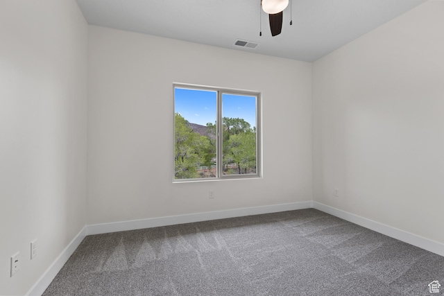 carpeted spare room featuring baseboards, ceiling fan, and visible vents