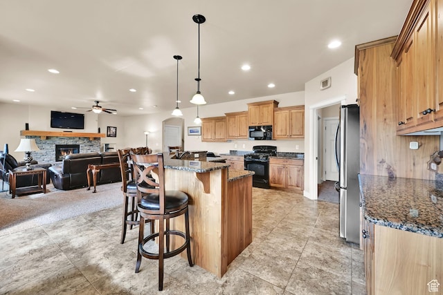 3182 N 1350 W, Pleasant View, UT 84414 - kitchen featuring black appliances, a kitchen breakfast bar, a ceiling fan, open floor plan, and dark stone countertops