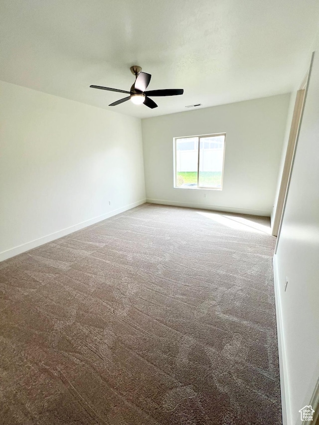 spare room with ceiling fan, baseboards, visible vents, and carpet floors