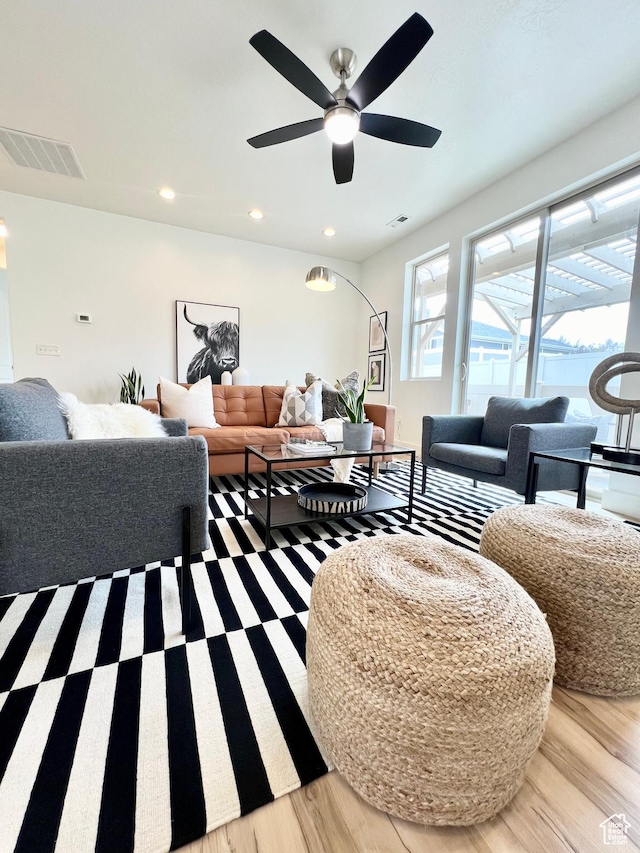 living area with visible vents, ceiling fan, and light wood-style flooring