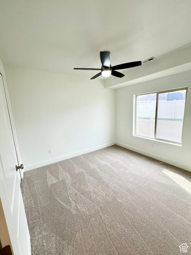 spare room featuring visible vents, baseboards, a ceiling fan, and carpet flooring