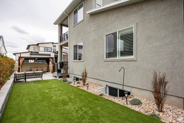 14902 S Fawley Ln, Herriman, UT 84096 - back of property featuring a yard, a patio, stucco siding, and an outdoor living space