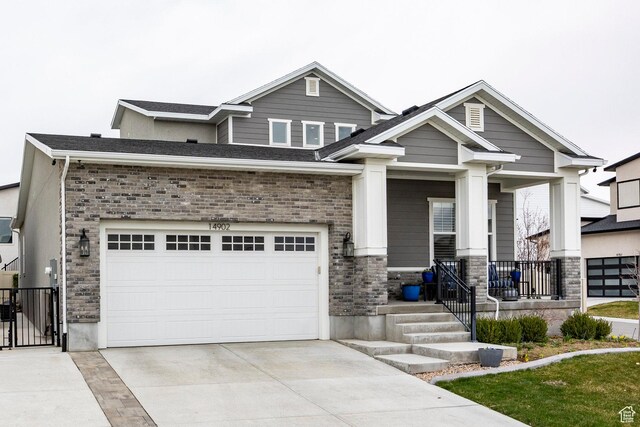 14902 S Fawley Ln, Herriman, UT 84096 - craftsman-style home featuring a porch, a gate, driveway, and stone siding