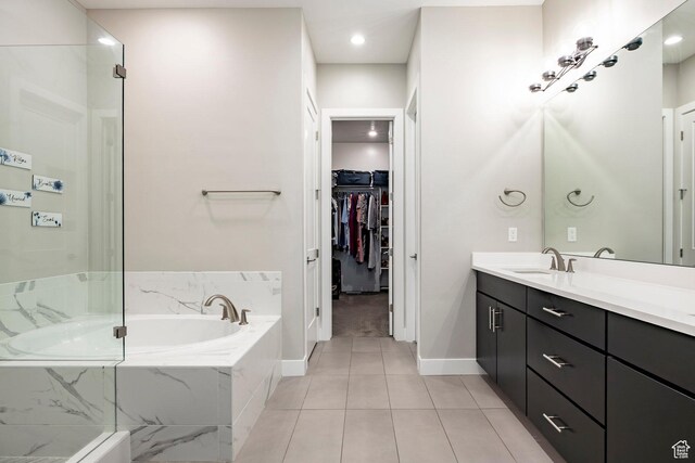 14902 S Fawley Ln, Herriman, UT 84096 - full bathroom featuring a walk in closet, a bath, vanity, baseboards, and tile patterned floors