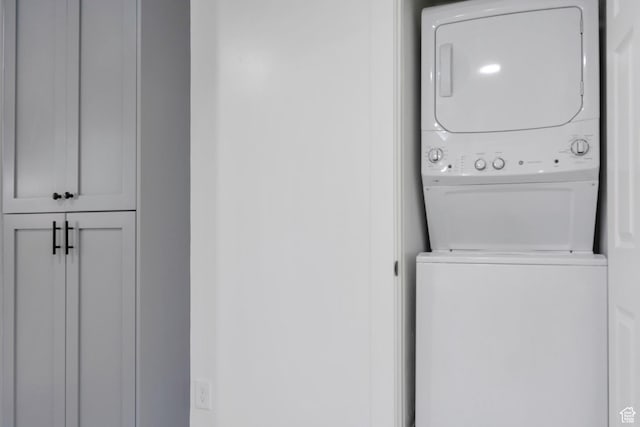 clothes washing area featuring laundry area and stacked washing maching and dryer