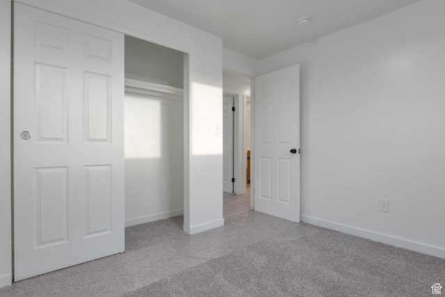 unfurnished bedroom featuring carpet floors, baseboards, and a closet