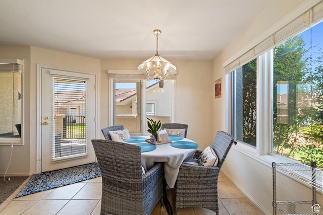 dining space featuring an inviting chandelier, light tile patterned floors, and baseboards