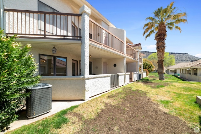 view of yard with a balcony, central air condition unit, and a mountain view