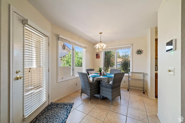 dining room with light tile patterned floors, a notable chandelier, and baseboards