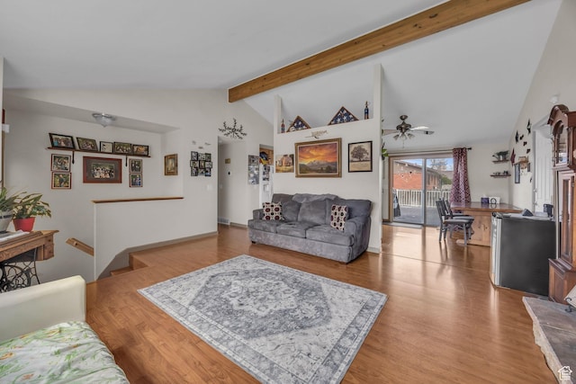 living room with lofted ceiling with beams, wood finished floors, and ceiling fan