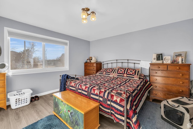 bedroom with baseboards and wood finished floors