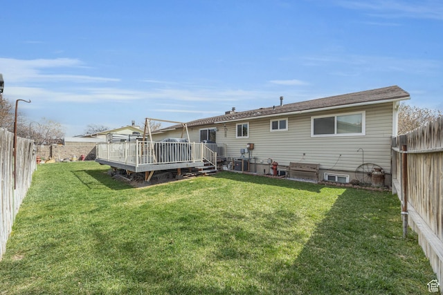 back of house featuring a fenced backyard, a yard, and a wooden deck