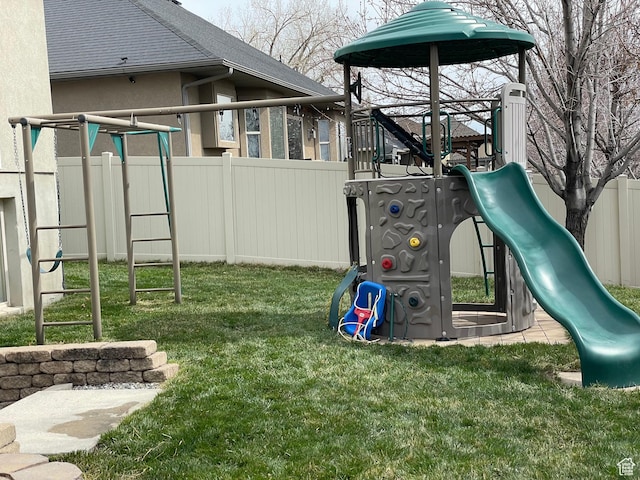 community jungle gym featuring fence and a lawn