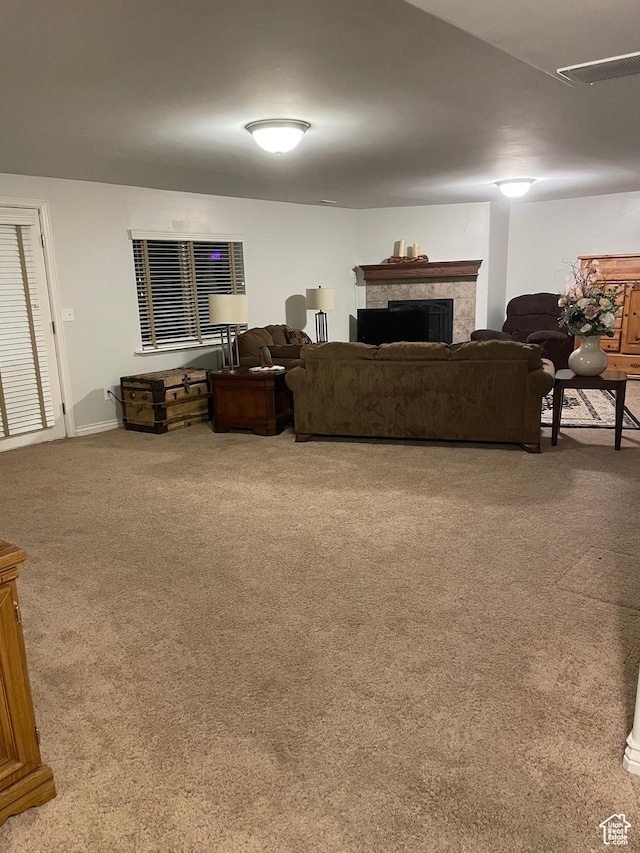 carpeted living room with a fireplace and visible vents