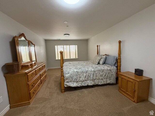 bedroom featuring baseboards and light colored carpet