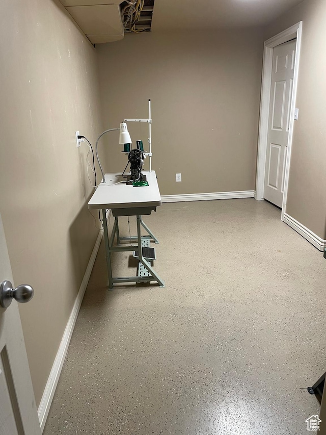 unfurnished office featuring baseboards and speckled floor