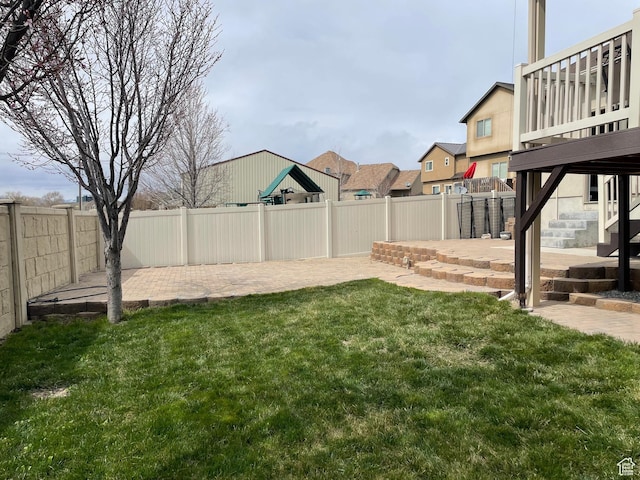 view of yard with stairs, a fenced backyard, and a patio area