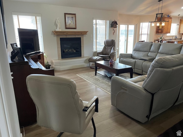 living room with light wood-style flooring and a tile fireplace