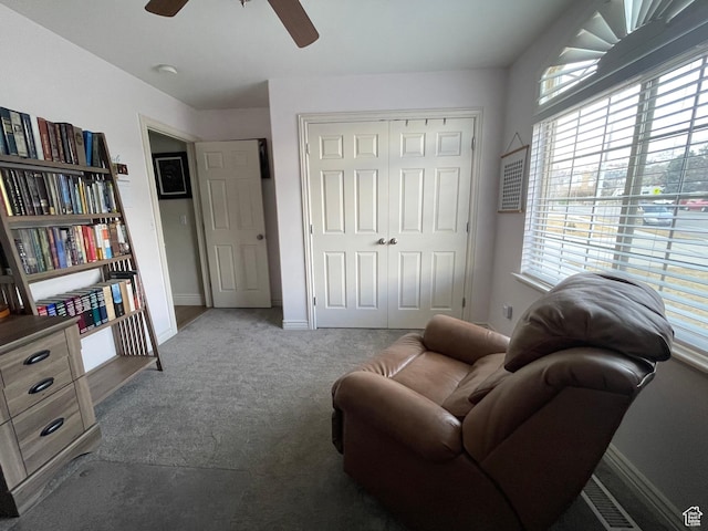 living area featuring baseboards, carpet flooring, and ceiling fan