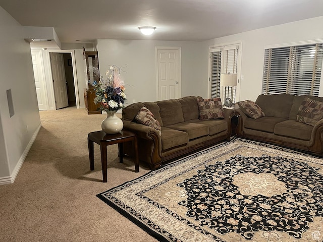 carpeted living area featuring baseboards