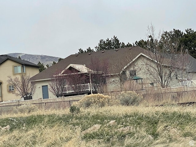 view of front of house featuring stucco siding and fence