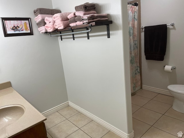 bathroom with baseboards, toilet, tile patterned floors, and vanity