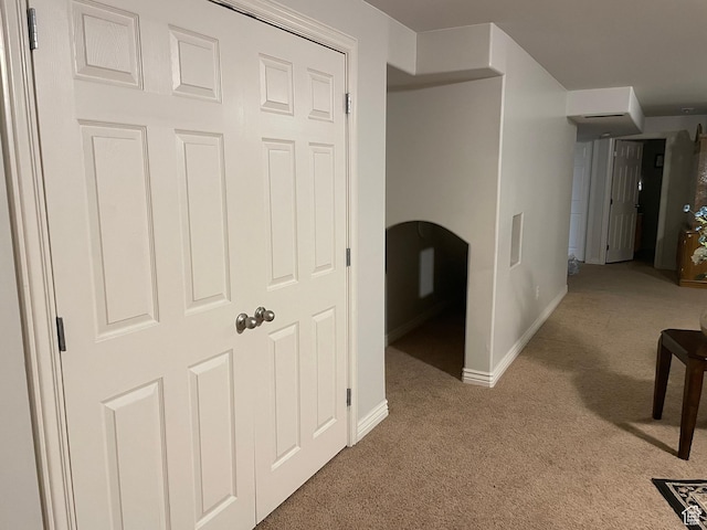 hall featuring baseboards and carpet floors