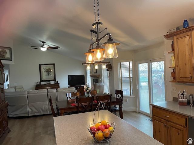 dining room with light wood-style floors, lofted ceiling, and ceiling fan
